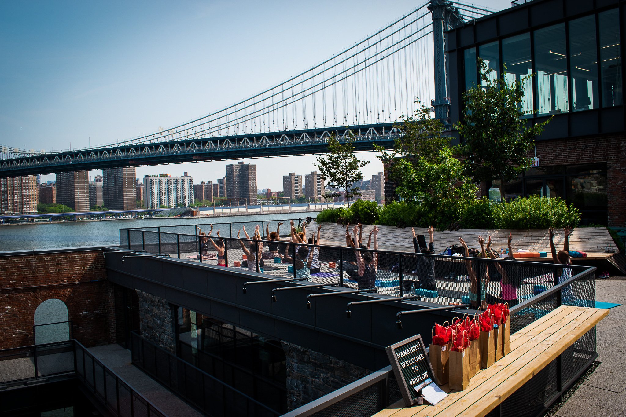 A rooftop BBFLOW yoga class with the Manhattan Bridge in the background