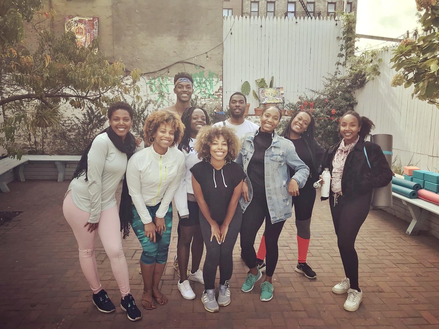 A BBFLOW class posing together after practice in a Brooklyn backyard